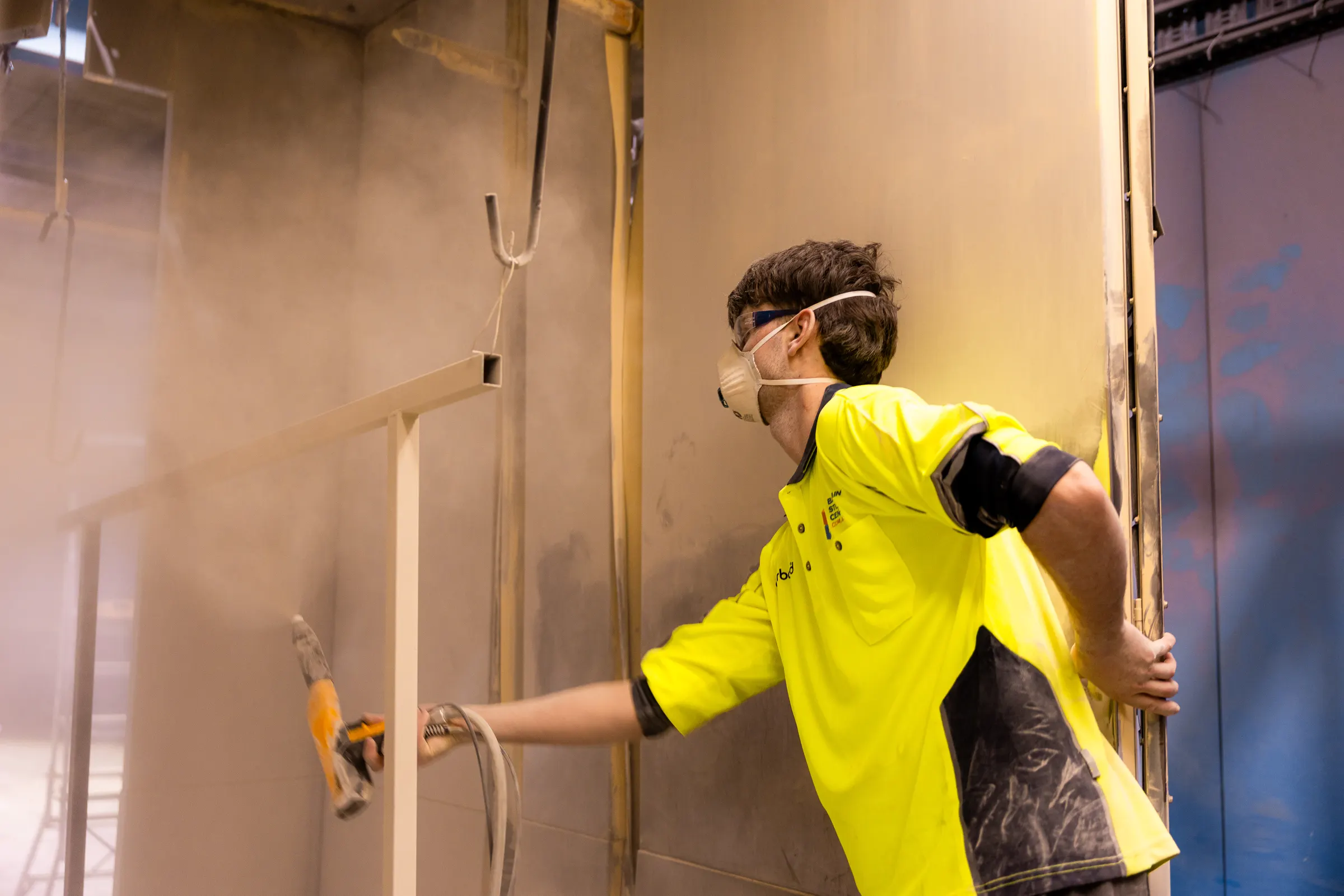 Applying powder coating in the spray booth